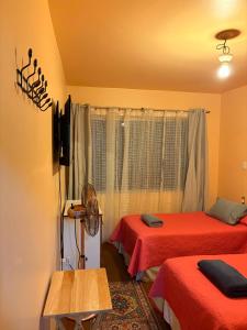 a room with two beds and a window at Hospedaje Rios in Osorno +8 photos