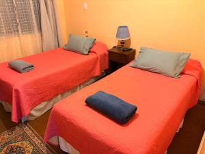 a room with two beds with red sheets at Hospedaje Rios in Osorno