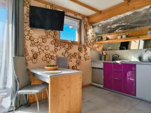 a kitchen with purple cabinets and a counter top at Lux Houses w DOMKU tylko DWA APARTAMENTYz jacuzzi zewnętrznym in Groń