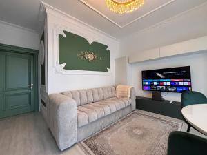 a living room with a couch and a flat screen tv at Vert Unique Luxury Experience in Băile Felix in Baile Felix