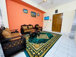 a living room with a couch and a rug at Sylhet three bedroom apartment in Sylhet