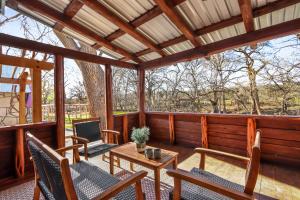a screened in porch with chairs and a table at Dew Drop Inn in Wimberley