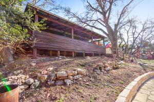 a wooden house with a pile of rocks in front of it at Dew Drop Inn in Wimberley +16 photos