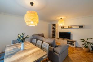 a living room with a table and chairs and a television at Villa Si y No in Gijón