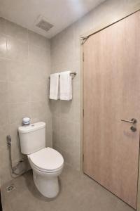 a bathroom with a toilet and a door with towels at Modern Apartment with Gym & Pool in Kathu