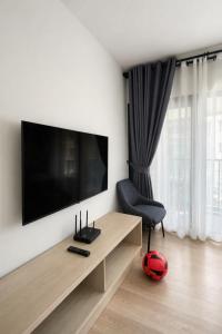 a living room with a television on a wall at Modern Apartment with Gym & Pool in Kathu