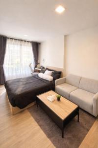 a living room with a bed and a couch at Modern Apartment with Gym & Pool in Kathu