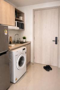 a kitchen with a washing machine in a kitchen at Modern Apartment with Gym & Pool in Kathu +2 photos