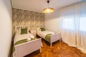 a bedroom with two beds and a window at Villa Si y No in Gijón