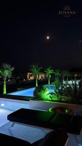 a view of a swimming pool at night at ZOSANA Villa in Kallithea Halkidikis