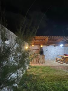 a patio at night with a picnic table at Casaacochego in Icapuí