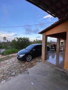 a black car parked inside of a garage at Casaacochego in Icapuí