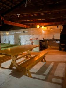 a wooden picnic table in a large room at Casaacochego in Icapuí
