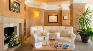 a living room with two chairs and a fireplace at Hotel Poseidon in Terracina
