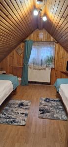 a room with two beds and two rugs at Pensiunea Floarea Dornei in Şarul Dornei