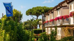a building with flowers on the balconies and a flag at Hotel Poseidon in Terracina
