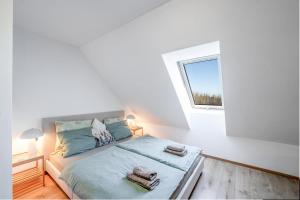 a white bedroom with a bed with towels on it at Studio Arnoštka in Vimperk