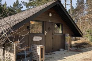 a small wooden cabin with a sign on the door at 2614-Romo-Stormengevej-18 in Høm