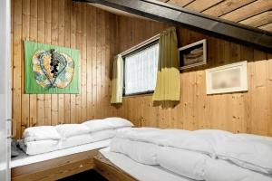 a room with a bed in a wooden wall at 2614-Romo-Stormengevej-18 in Høm