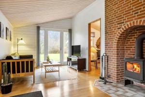 a living room with a fireplace and a brick wall at LF14348-Roslev-Harrebjergvej-48 in Harre