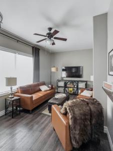 a living room with two couches and a ceiling fan at Walkerton Sauna Suite in Walkerton