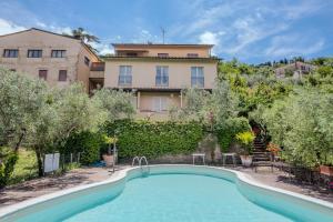 a swimming pool in front of a house with trees at B&B La Bufalona - Pool & Relax in Massa Marittima