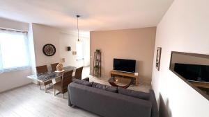 a living room with a couch and a tv at La Halte Montbrisonnaise in Montbrison
