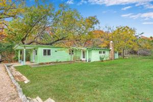 a green house with a lawn in front of it at Cypress Moon in Wimberley