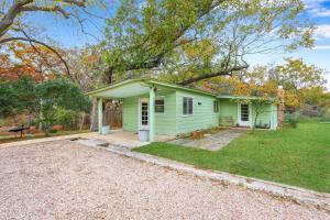 a green house with a driveway in front of it at Cypress Moon in Wimberley +31 photos