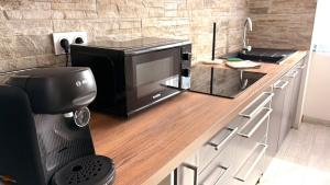 a microwave sitting on a counter in a kitchen at La Halte Montbrisonnaise in Montbrison