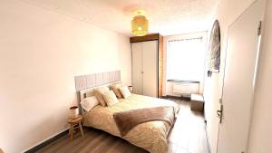 a small bedroom with a bed and a window at La Halte Montbrisonnaise in Montbrison