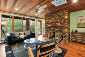 a living room with a couch and a stone fireplace at Cypress Star in Wimberley