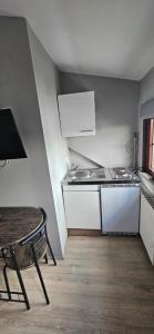 a small kitchen with a table and a sink at Pension Raunheim in Raunheim