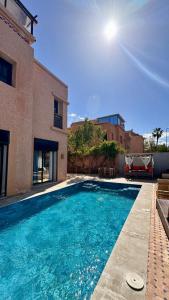 a swimming pool in front of a house at Villa de prestige à Marrakech in Marrakesh