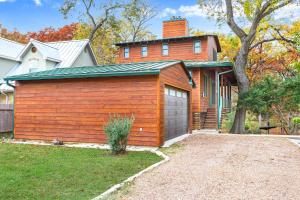 a wooden building with a garage in front of a house at Cypress Star in Wimberley