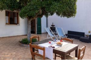 a wooden table and chairs sitting under a tree at Padulella Mare - HelloElba in Portoferraio