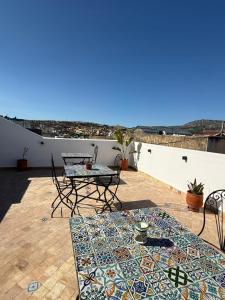 a patio with a table and chairs on a roof at Riad Mira in Fez