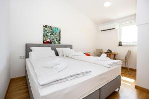 a bedroom with a large white bed with white pillows at Sarajevo Boutique Studios in Sarajevo