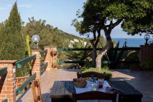 a table and chairs on a patio with a view of the ocean at Padulella Mare - HelloElba in Portoferraio