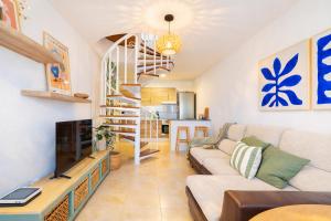 a living room with a couch and a spiral staircase at Profithome- Brisas de Güimar in Puertito de Güímar