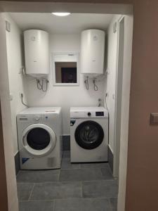 a laundry room with a washing machine and a washer at IN Kala in Rijeka