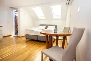 a room with a bed and a table and a bed and a dining room at Sarajevo Boutique Studios in Sarajevo