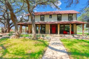 a house with a red door and trees at D2 Farms in Wimberley