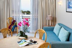 a living room with a table and a blue couch at Luna Clube Oceano in Albufeira