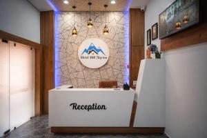 a reception area at a hotel with a sign on the wall at hotel hill top inn vatva in Ahmedabad