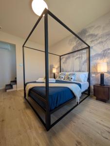 a bedroom with a canopy bed with blue sheets at La Sosta del Cardinale in Montefiascone
