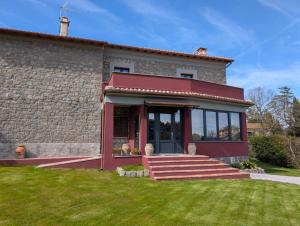 a house with a red front door and a lawn at La Sosta del Cardinale in Montefiascone