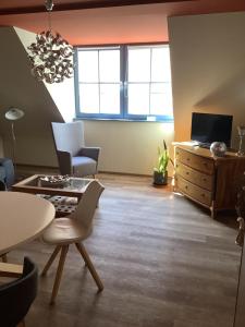 a living room with a table and chairs and a tv at Ferienwohnung Himmel und Hölle in Freiberg