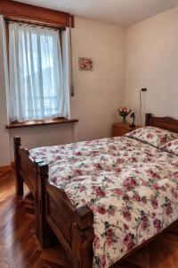 a bedroom with a bed with a floral bedspread at Appartamento Alta Valle Maira - Midia in Villaro