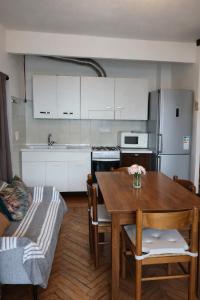 a kitchen with a wooden table and a kitchen with white cabinets at Appartamento Alta Valle Maira - Midia in Villaro